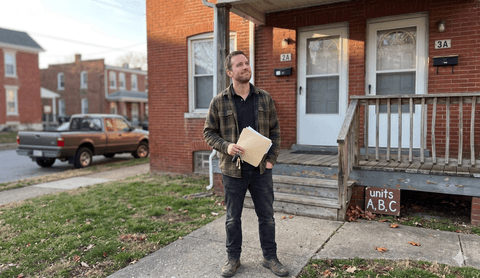 Investor with paperwork outside his triplex